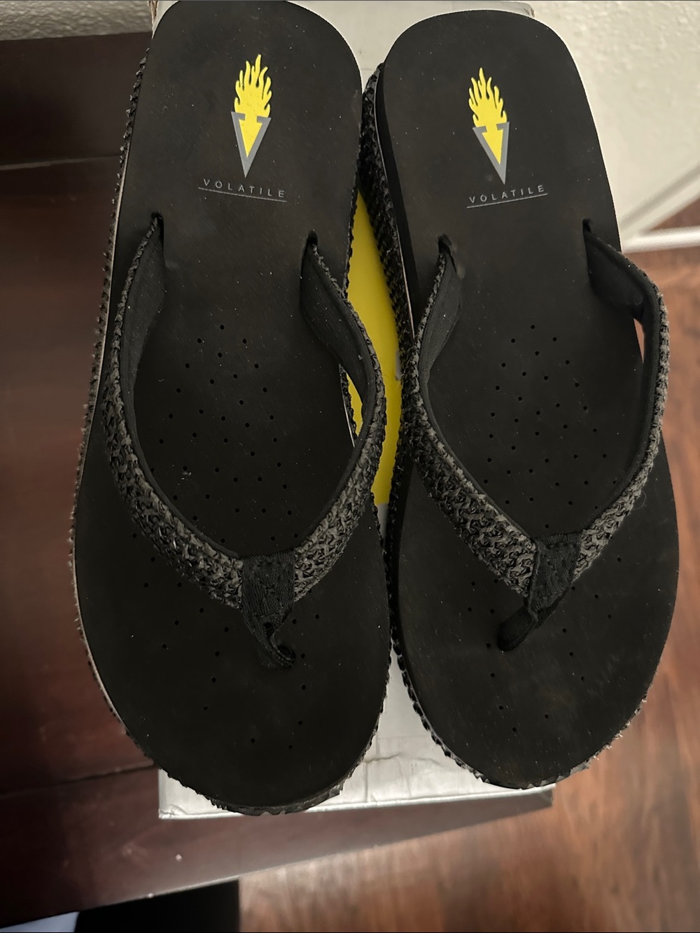 Volatile Black Flip Flop Sandals with Yellow Logo